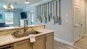 A kitchen with a marble countertop, a sink, and a towel hanging on the cabinet. - New! Oceanview Oasis whole house - Theater - Screened Porch - Sundeck - Grill (Marathon)