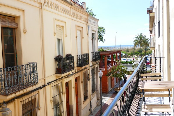 A building with balconies, a street view, and a distant beach. - House for 7 · 100m Beach · Terrace & Parking · Arenys de Mar
3️⃣ (80 caracteres) (Arenys de Mar)