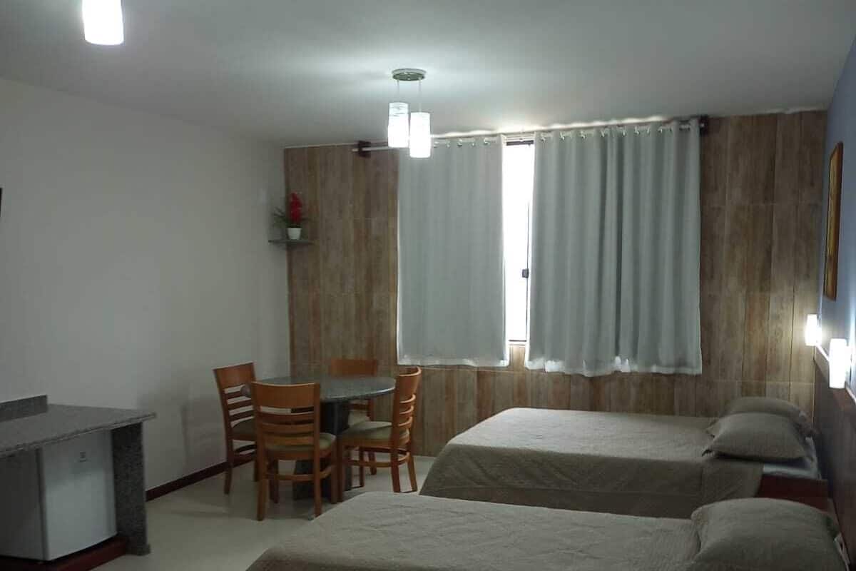 Une chambre d’hôtel avec deux lits, un bureau et une chaise.