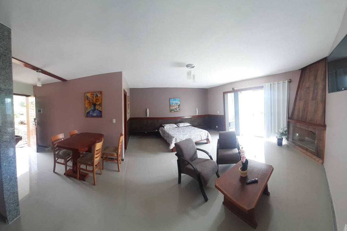 Une chambre d’hôtel spacieuse, dotée d’un grand lit, d’un coin repas avec une table et des chaises, et d’un petit coin salon avec une table et des chaises.