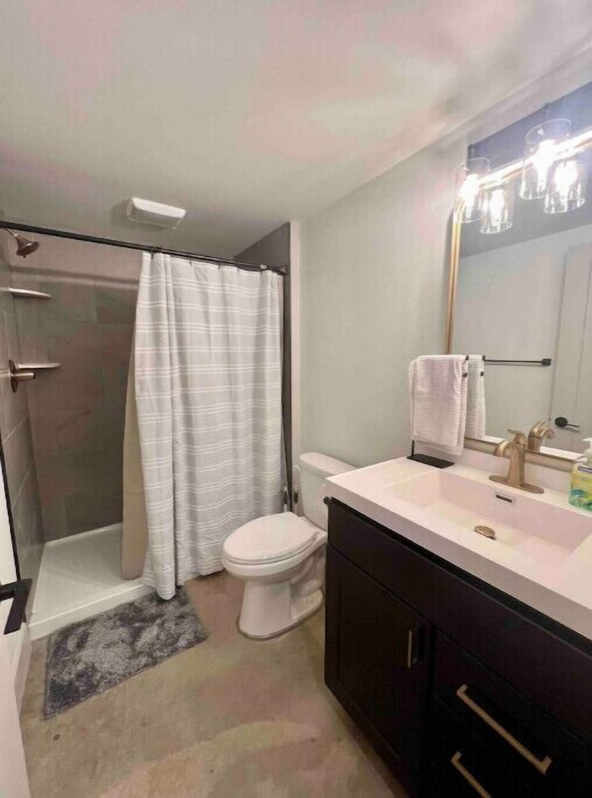 Un baño moderno con ducha, inodoro y tocador.