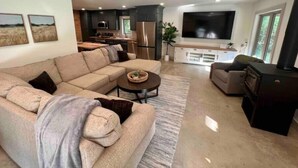 Un salon moderne avec un canapé d’angle, une table basse et une cheminée.