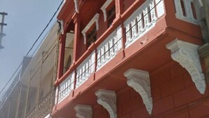 A red building with white decorative elements and multiple windows. - C. Deán Valdivia 120 (Arequipa)