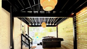 Un espace intérieur doté d’un sol en béton, d’une rambarde noire et d’un luminaire suspendu.