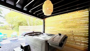 Un bain à remous avec un mur en bois et un luminaire suspendu.