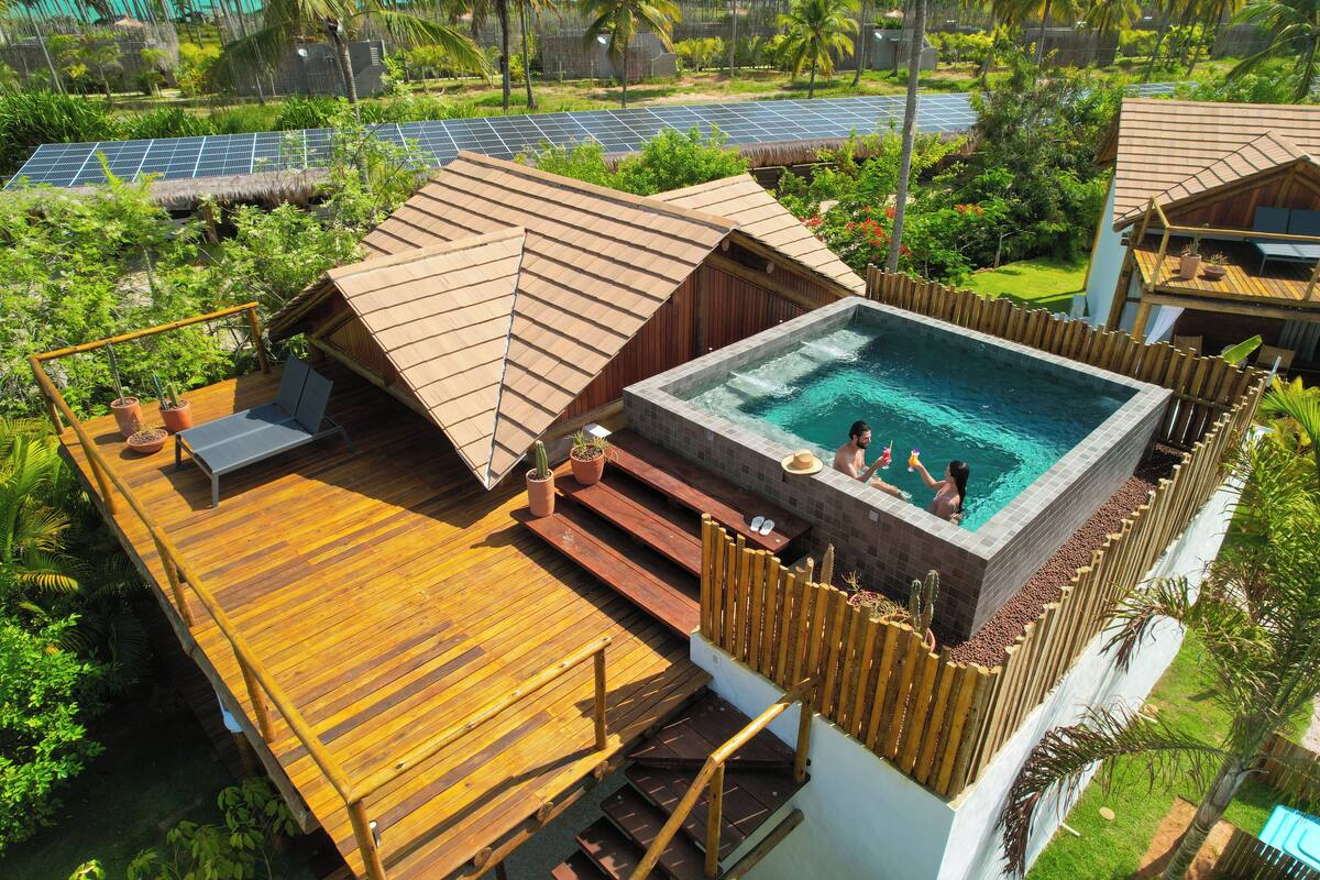 A resort with a rooftop pool, wooden deck, and solar panels.