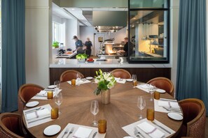 Un comedor con una mesa redonda dispuesta para seis personas, rodeada de sillas.