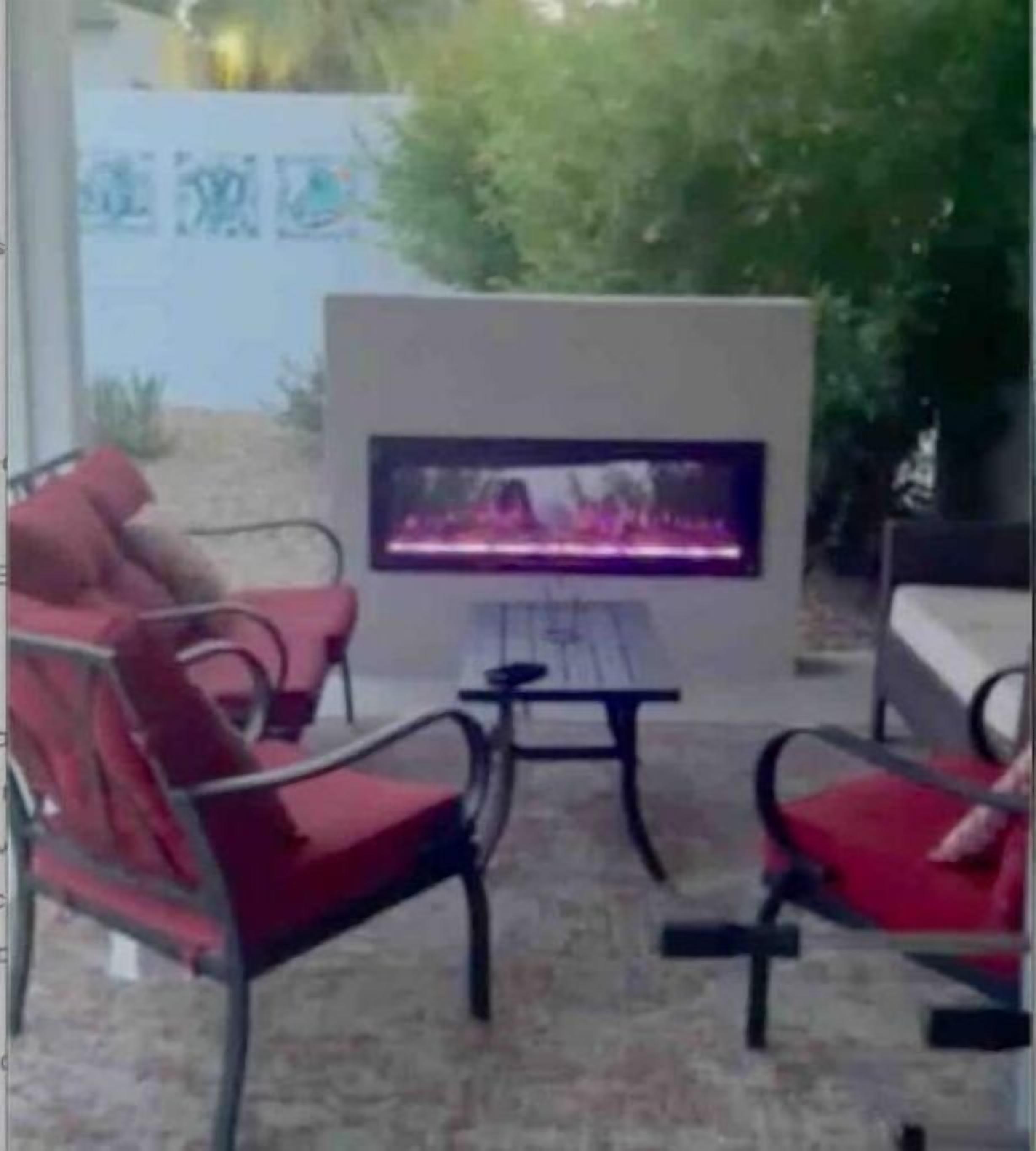 Un espace patio équipé d’un téléviseur à écran plat, de chaises rouges et d’une table.
