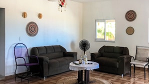 A spacious living room with two sofas, a round coffee table, and a decorative chandelier. - Pousada Mar das Gaivotas (Cajueiro da Praia)