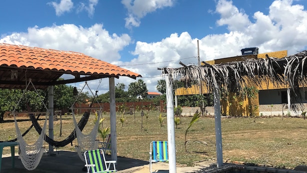 A swimming pool with lounge chairs and a covered seating area. - Pousada Mar das Gaivotas (Cajueiro da Praia)