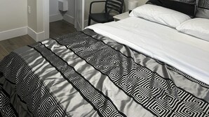 Ein Schlafzimmer mit Bett, Stuhl, Kleiderschrank und Klimaanlage.
