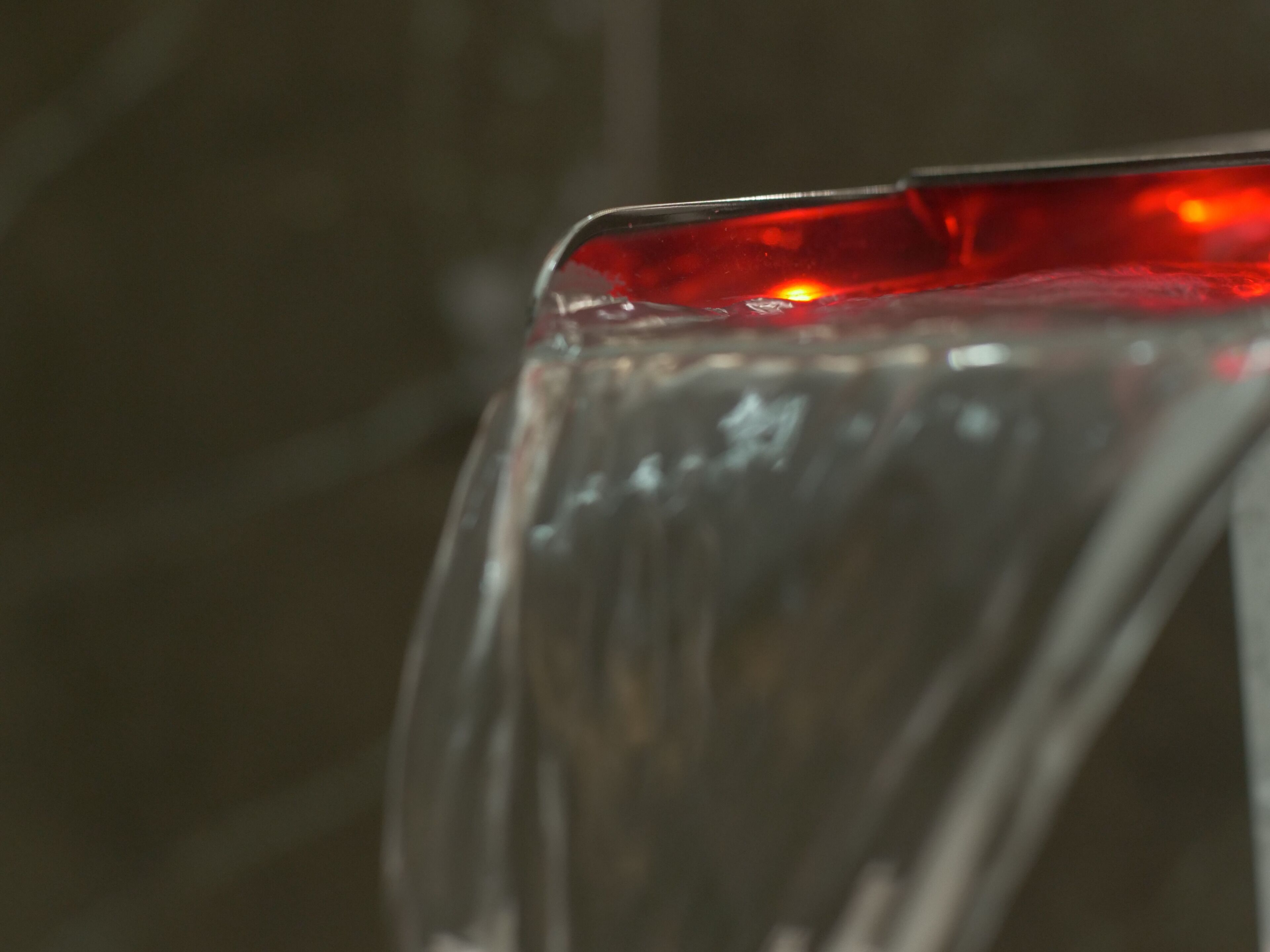 Primer plano de un objeto de vidrio con un tono rojo.
