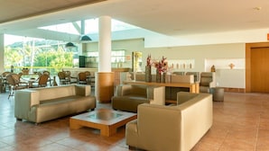 A spacious lobby with multiple seating areas, a central coffee table, and a view of the outdoors. - Beach Class Resort  (Ipojuca)