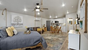 A bedroom with a bed, a ceiling fan, and a view into the kitchen. - Sweet Suite Retreat,  Studio apartment in Cedar City (Enoch)