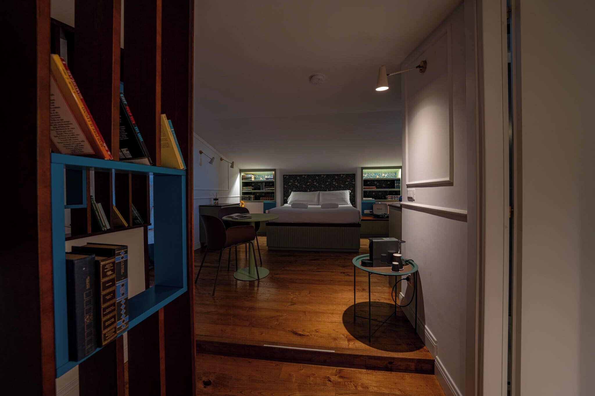 A bedroom with a bed, bedside tables, a desk, and a bookshelf.