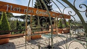 A wrought iron gate with a wooden sign that reads "Non piu Competere con L'amore." - Giardini Penelope Resort e Spa (Ciampino)