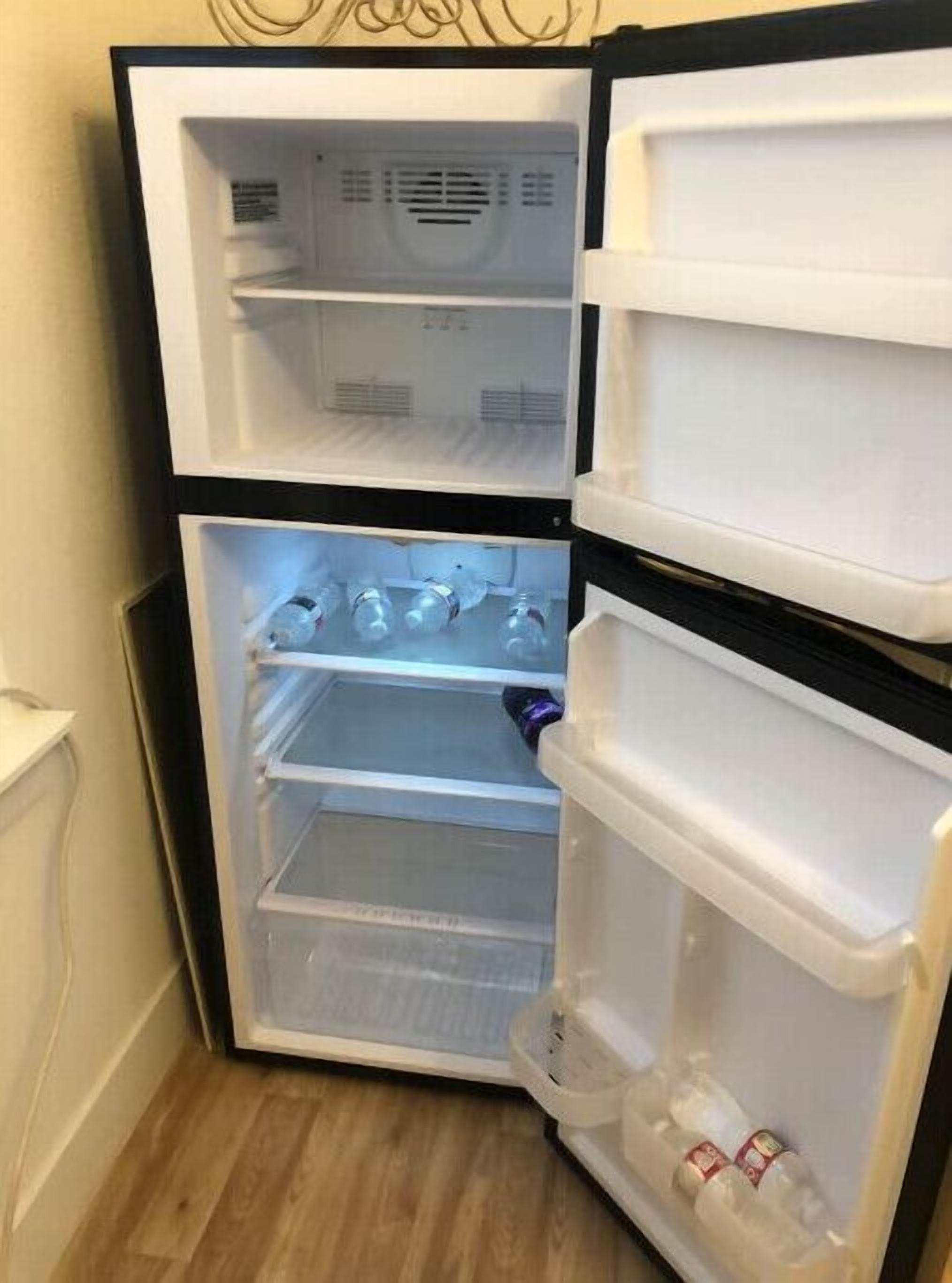 A compact refrigerator with two door compartments and a freezer section.