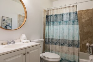 A bathroom with a white sink, a toilet, a bathtub, and a shower curtain with a geometric pattern. - 247 Mesa (Mesa)