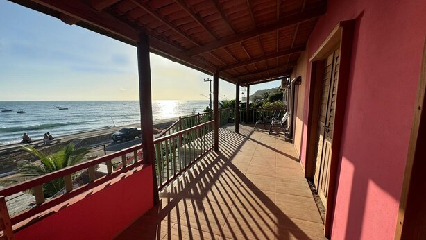 A covered balcony with a view of the beach and ocean. - Chalé panulirus (Icapuí)