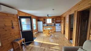 L’intérieur d’une cabane en bois comprend une cuisine, un coin repas et un espace de vie.