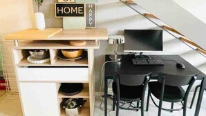 A compact kitchen with a wooden countertop, a black dining table with two chairs, and a computer setup. - Charming Duplex in Center w. 2 Terraces (Luxembourg City)
