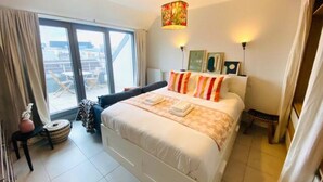 A hotel room with a large bed, a view through the window, and a decorative lamp. - Charming Duplex in Center w. 2 Terraces (Luxembourg City)