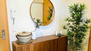 A bathroom with a wooden vanity, a round mirror, a potted plant, and a tiled floor. - Charming Duplex in Center w. 2 Terraces (Luxembourg City)