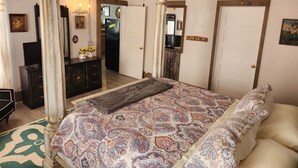 A bedroom with a large bed, a ceiling fan, and a dresser. - Unwind at the Lotus house Opal suite. (Lansing)