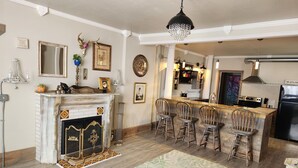A kitchen with a marble countertop, a built-in stove, and a black refrigerator. - Unwind at the Lotus house Opal suite. (Lansing)