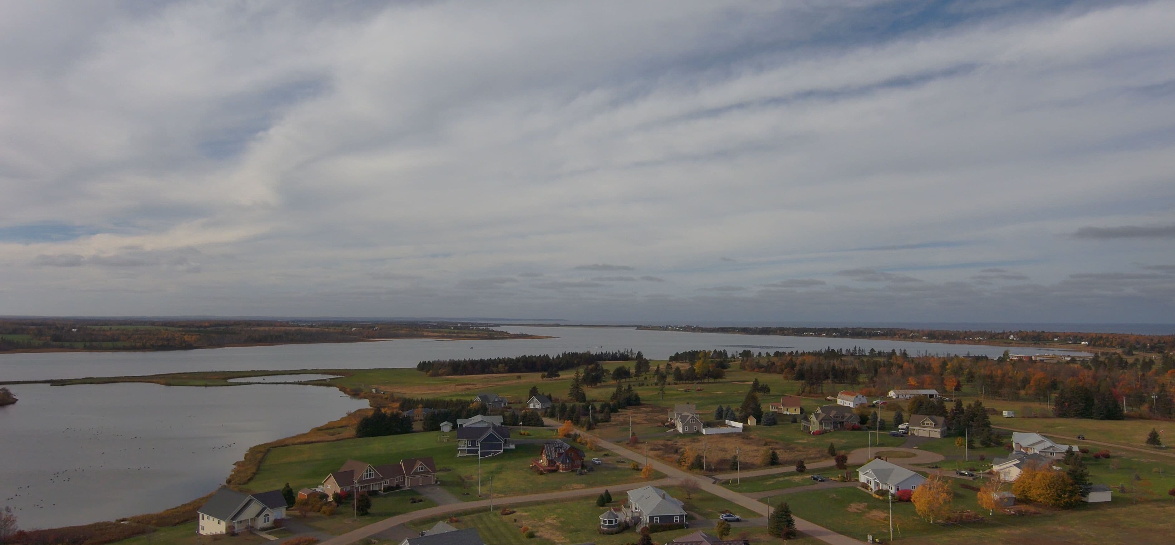 A lakeside residential area with houses, roads, and a large body of water.