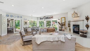 Ein geräumiges Wohnzimmer mit einer großen Couch, einem Kamin und einem Schild mit der Aufschrift 'Ice Cream'.