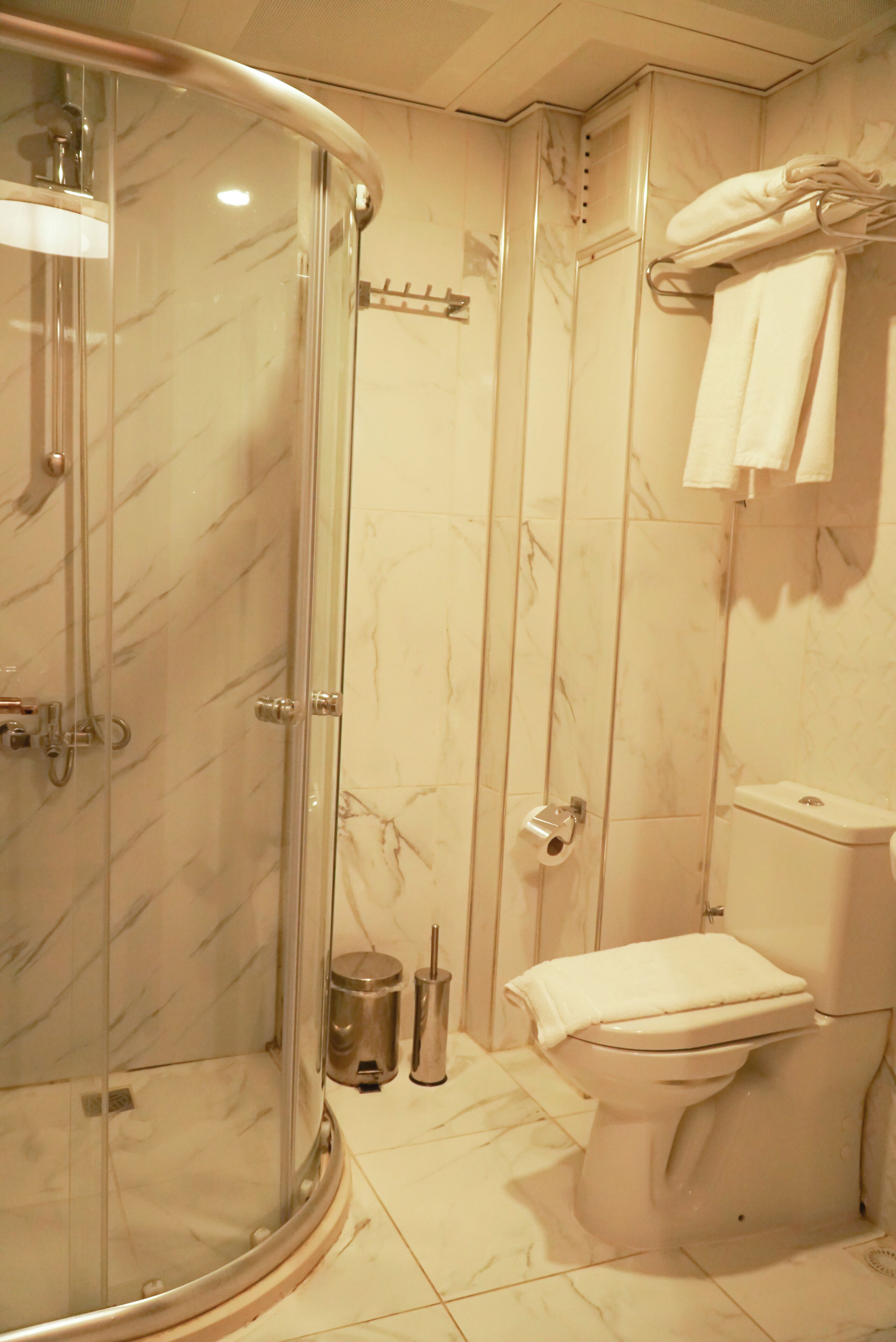 Un baño con ducha de vidrio, inodoro y lavabo.