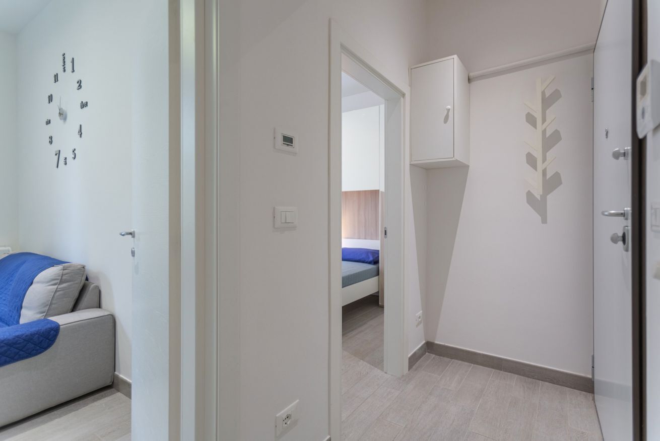 Een slaapkamer met een bed, een kledingkast en een wandklok.