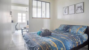 Une chambre à coucher avec un lit, une fenêtre et un tableau accroché au mur.