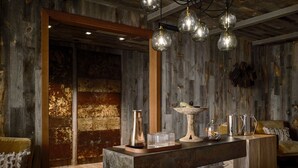 A rustic interior with a wooden ceiling, a central stone table, and hanging pendant lights. - Bowie House, Auberge Collection (Fort Worth)
