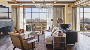 A spacious living room with a fireplace, large windows, and a view of a cityscape. - Bowie House, Auberge Collection (Fort Worth)
