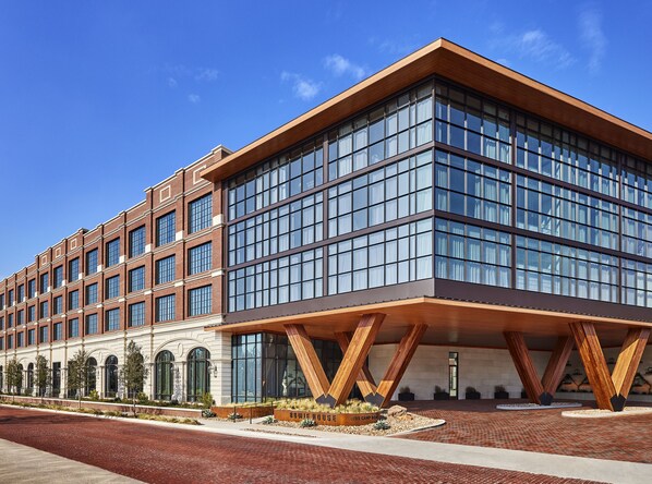 A modern hotel with a brick facade, large windows, and a distinctive wooden structure at the entrance. - Bowie House, Auberge Collection (Fort Worth)