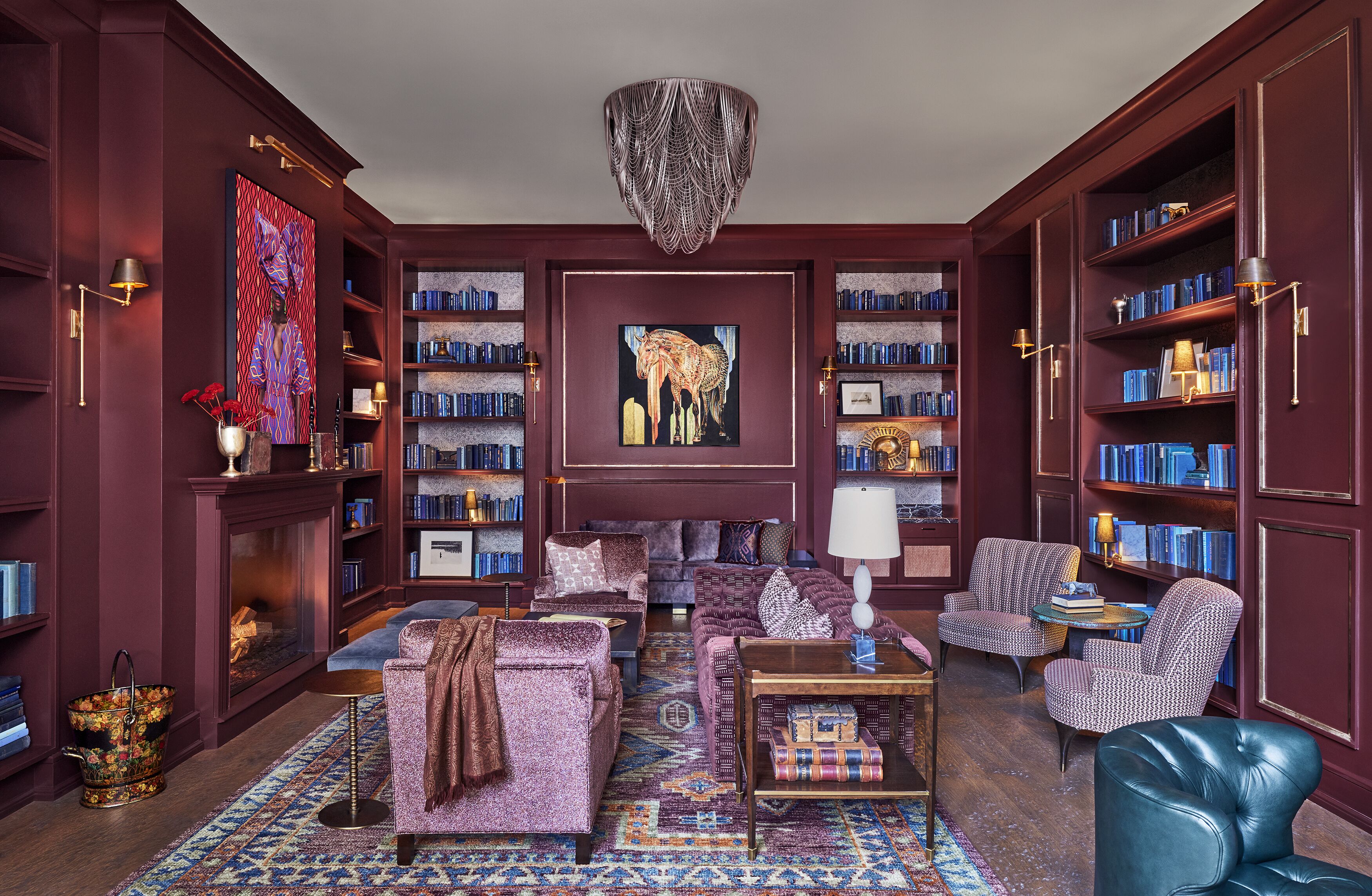 A library with bookshelves, a fireplace, and a sofa.