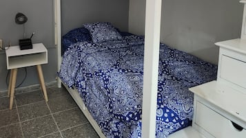 Una cama individual sobre otra y un escritorio con una lámpara.