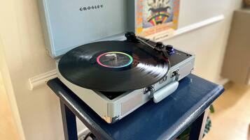 A Crosley turntable with a vinyl record on a blue stand.