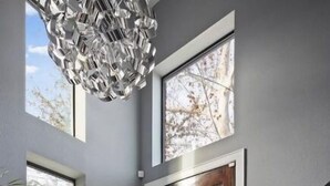 Un interno moderno con una scala, una grande finestra e un design di porta originale.