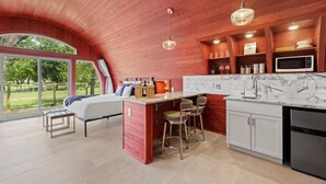 Une cuisine moderne dotée d’un plan de travail en marbre, de meubles en bois et d’un four à micro-ondes encastré.