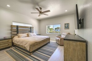 A bedroom with a bed, a desk, a chair, a ceiling fan, a window, and a painting on the wall. - Sebring Serenity: Waterfront Retreat w/ Boat Dock! (Sebring)