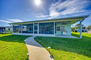 A modern house with a covered patio, a pathway, and a lawn. - Sebring Serenity: Waterfront Retreat w/ Boat Dock! (Sebring)