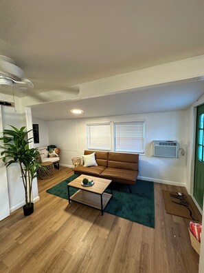 Relax in this inviting living space with a comfortable sofa, coffee table, and lush greenery.