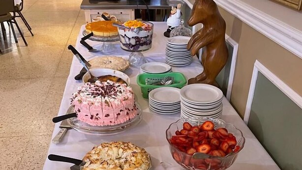Una mesa de buffet con diversos postres y frutas.