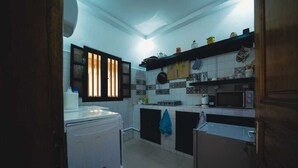 A compact kitchen with a washing machine, a microwave, and a sink.