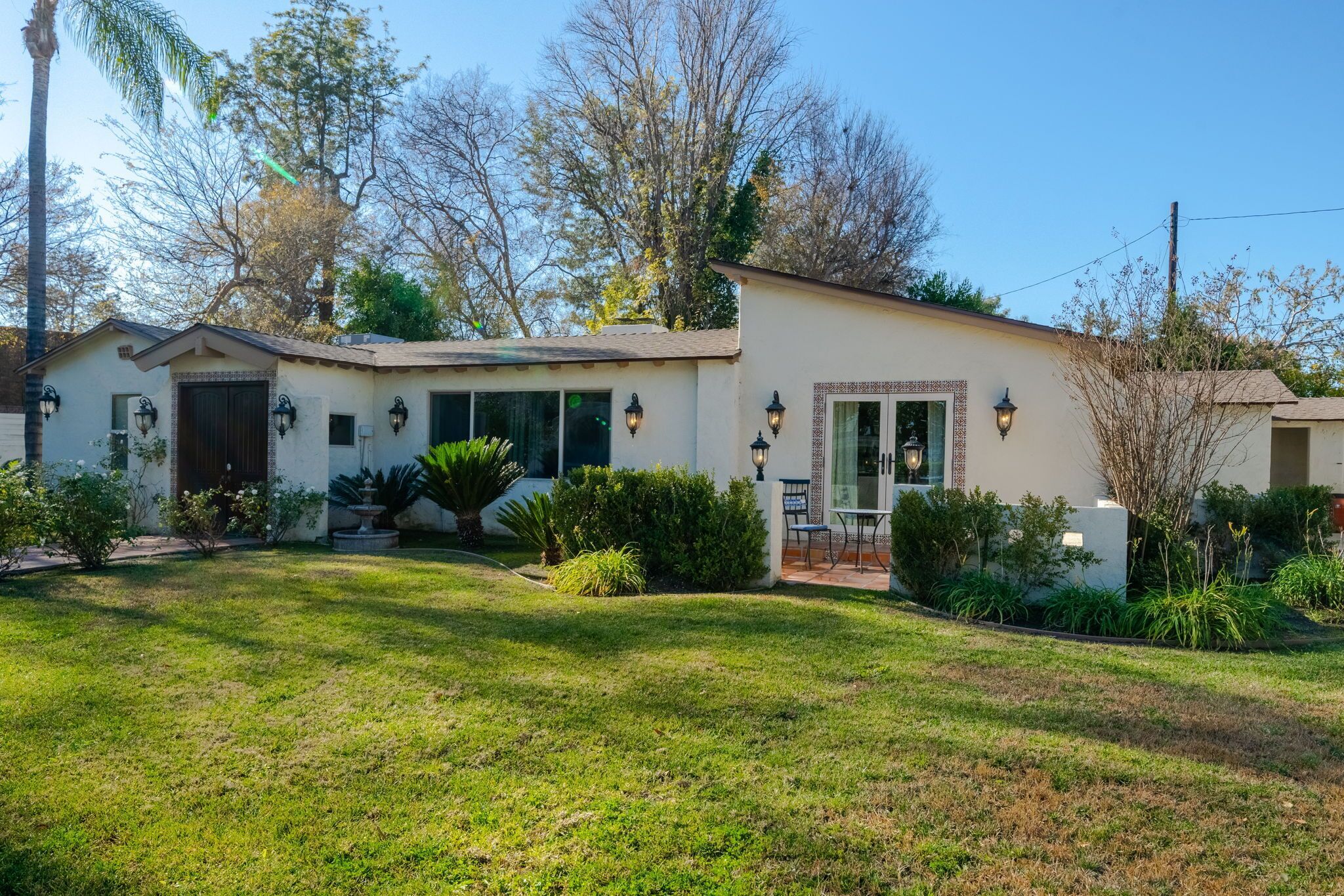 A single-story house with a front porch, a garage, and a small garden area.