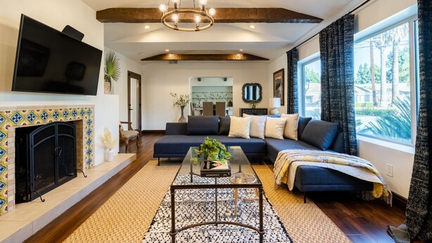 Una sala de estar moderna con chimenea, televisor de pantalla plana grande, sofá y mesa de centro.