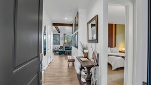 A hallway leading to a bedroom with a bed, a desk, and a chair. - Grand Canyon Brand New Home with AC. Near Golf Course, Lake & Bearizona (Williams)